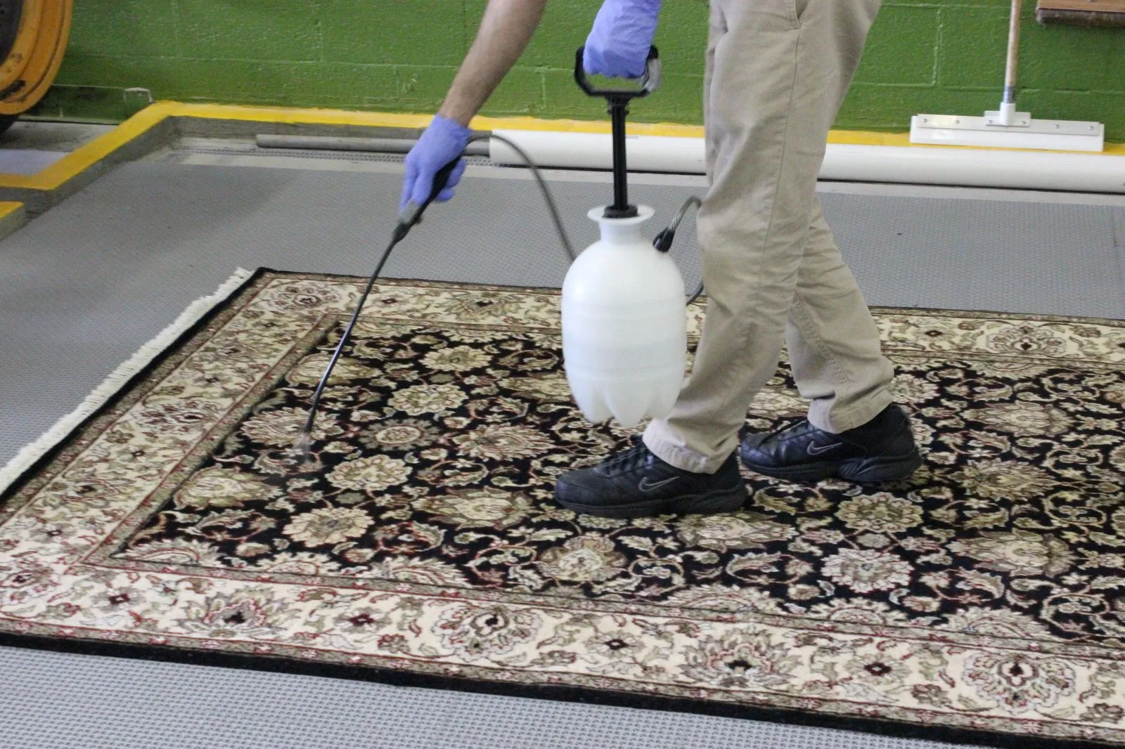 Rug spread across the wash floor and wetted down for pre-treatment before shampooing