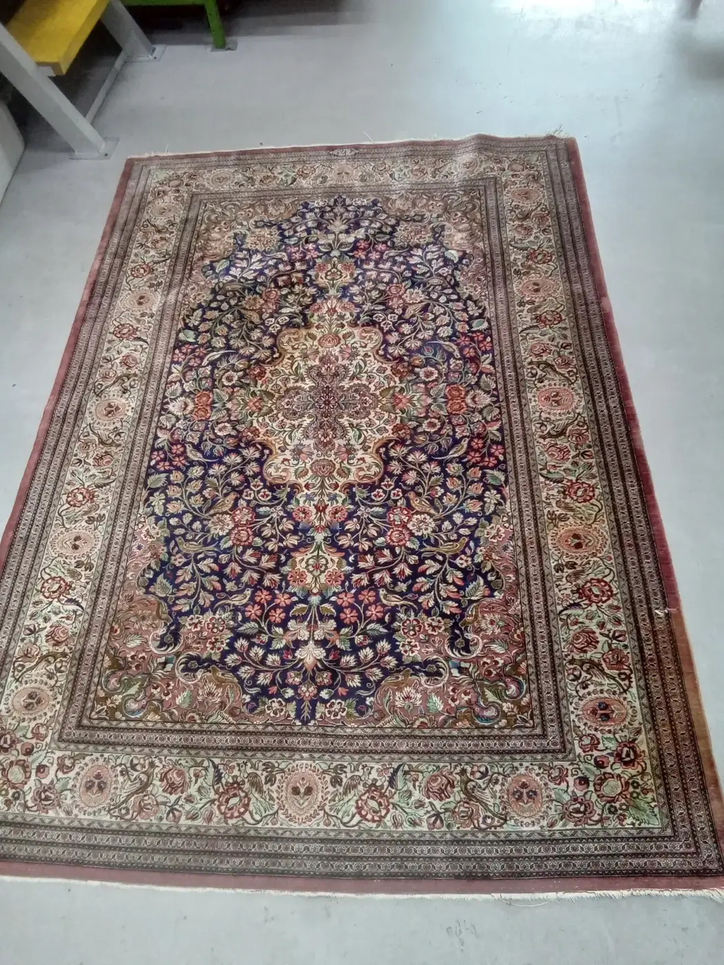 Fine navy-and-cream Persian rug standing on end, freshly cleaned